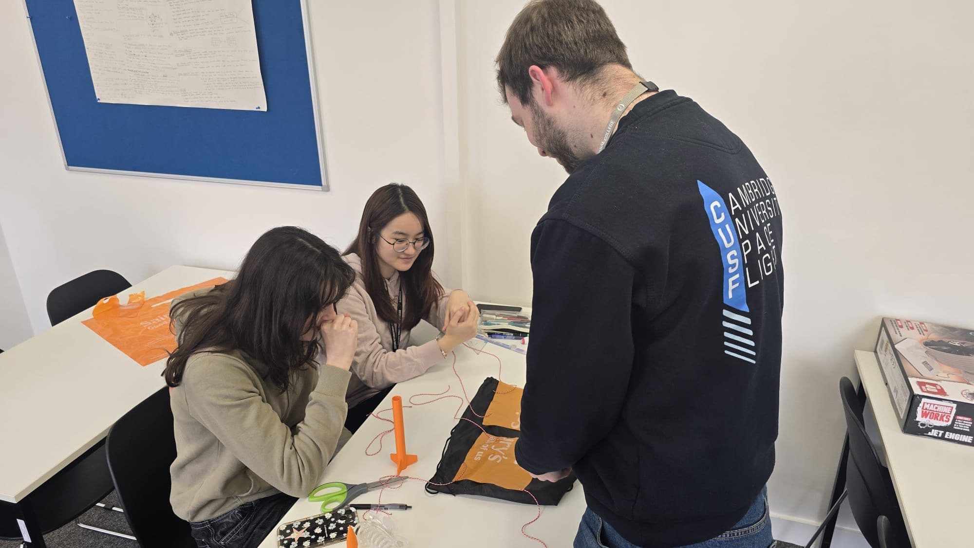 Students and a mentor collaborating on a hands-on STEM project at a table